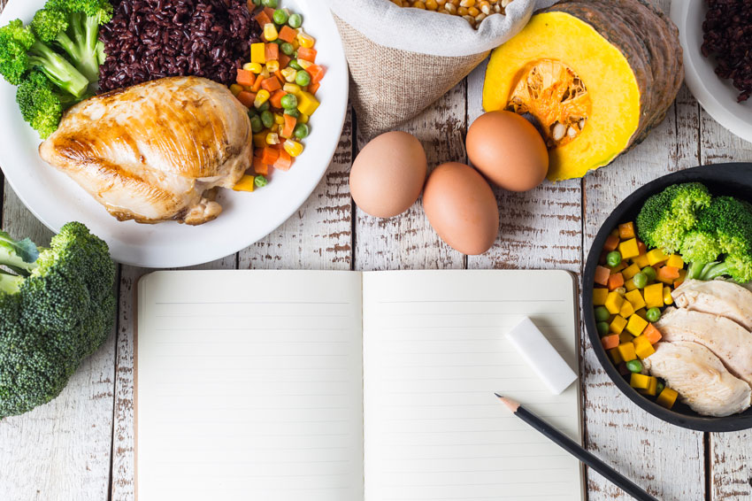 Plusieurs plats cuisinés sains posés sur une table avec un plan alimentaire